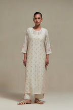 Off white silk Chanderi straight kurta set with all-over delicate embroidered flowers, highlighted with sequins and multi coloured beads.