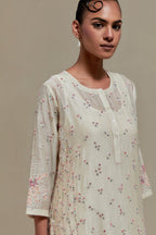 Off white silk Chanderi straight kurta set with all-over delicate embroidered flowers, highlighted with sequins and multi coloured beads.