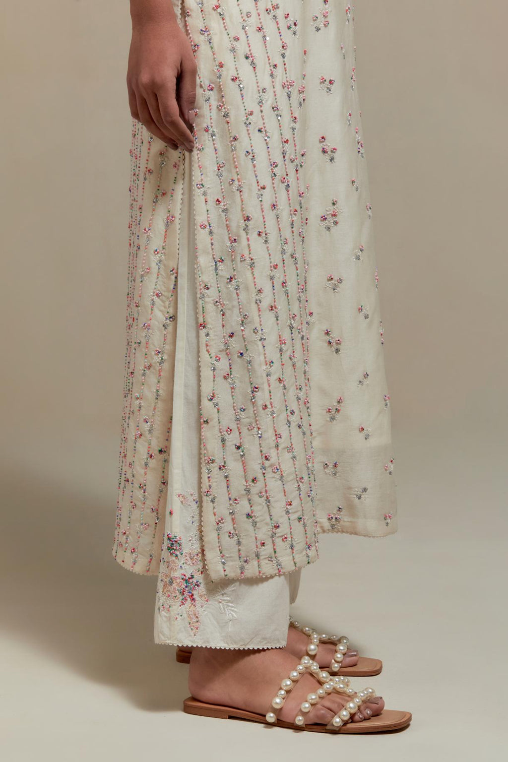 Off white silk Chanderi straight kurta set with all-over delicate embroidered flowers, highlighted with sequins and multi coloured beads.