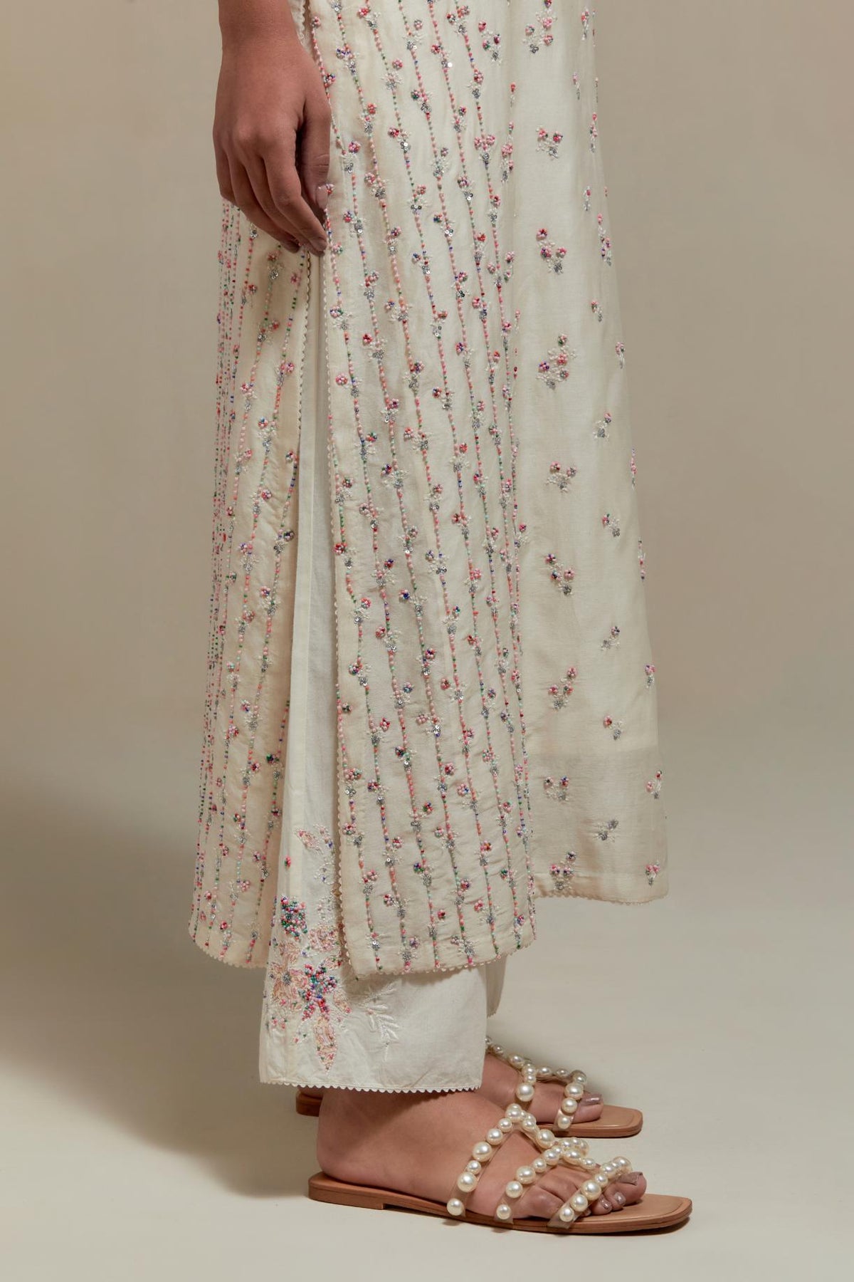 Off white silk Chanderi straight kurta set with all-over delicate embroidered flowers, highlighted with sequins and multi coloured beads.