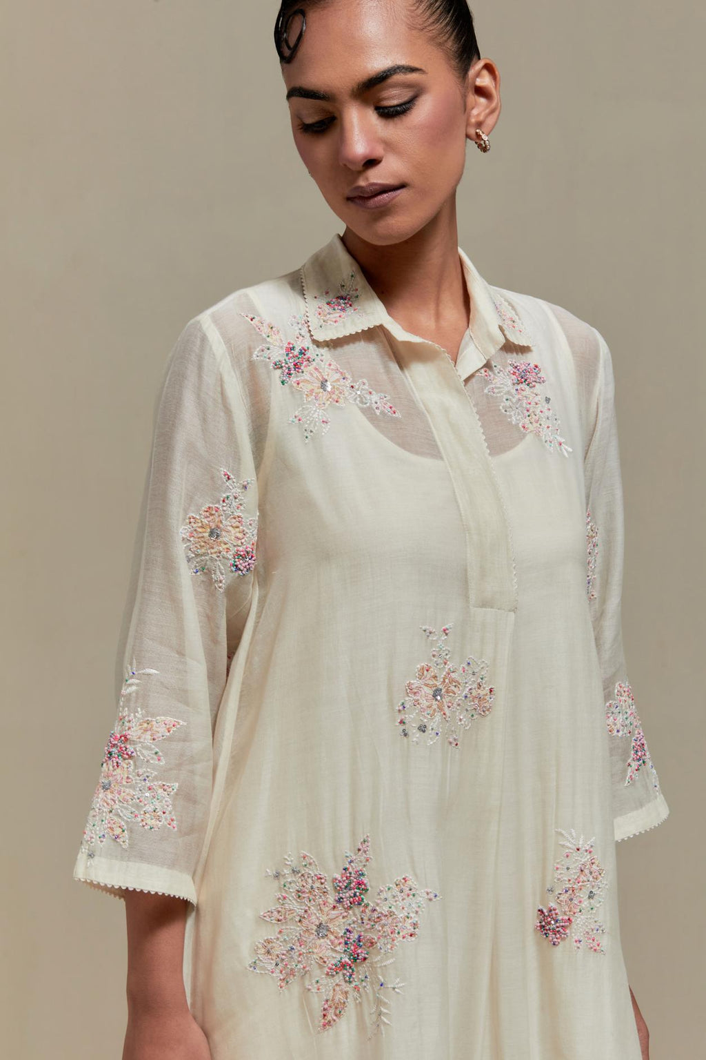 Off white cotton Chanderi short shirt-kurta set with all-over pink & beige hand block printed appliqué flowers, highlighted with sequins and multi-coloured beads.