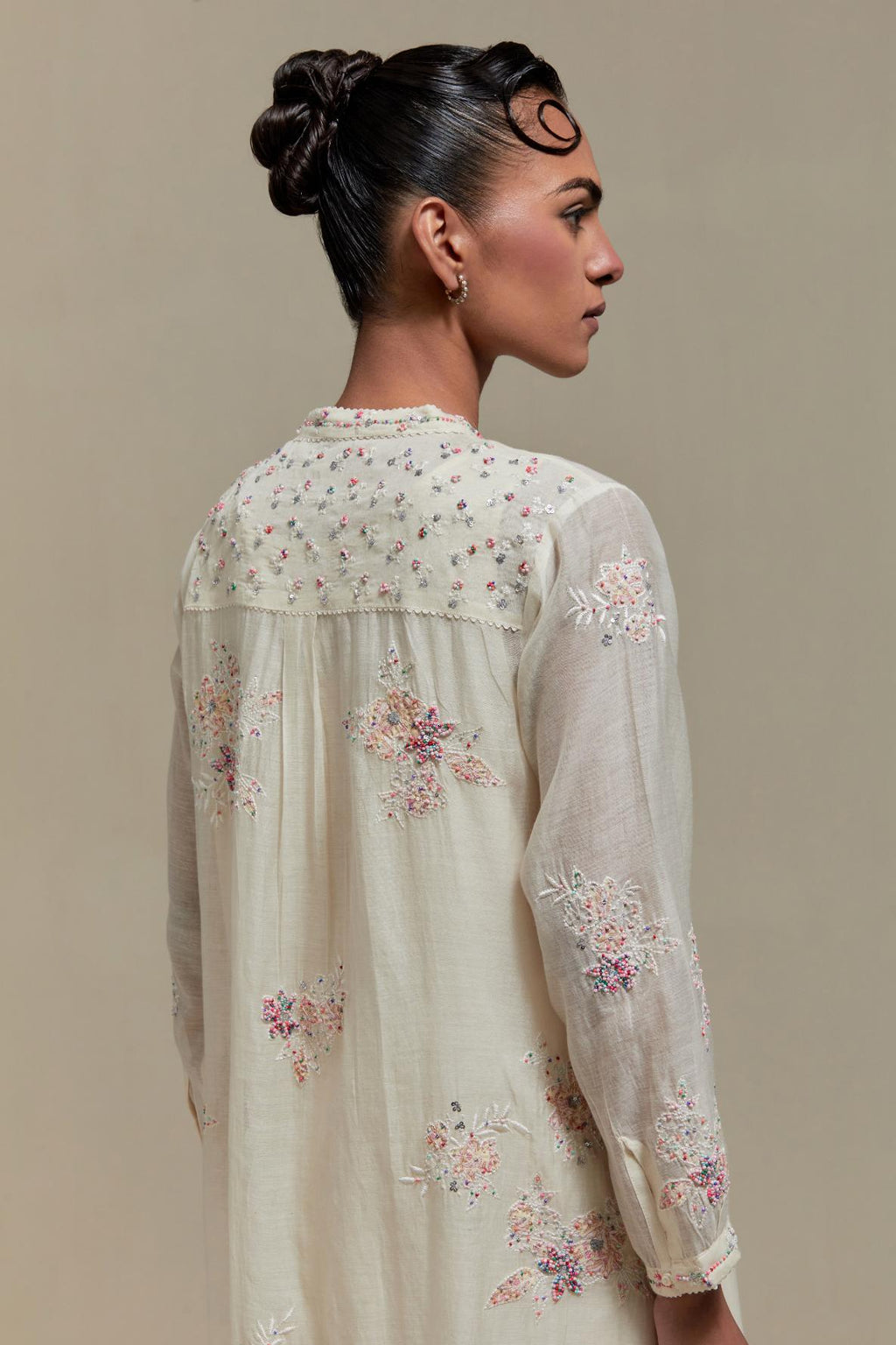 Off white cotton Chanderi short kurta set with all-over pink & beige hand block printed appliqué, highlighted with sequins and multi coloured beads.