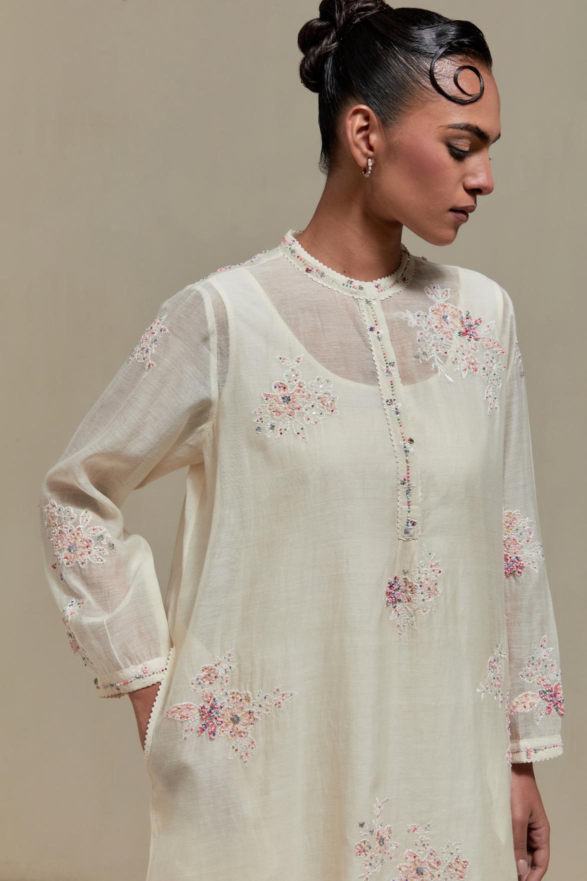 Off white cotton Chanderi short kurta set with all-over pink & beige hand block printed appliqué, highlighted with sequins and multi coloured beads.