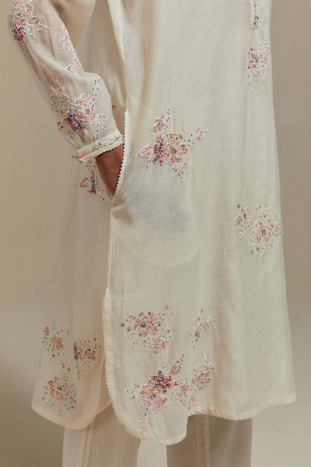Off white cotton Chanderi short kurta set with all-over pink & beige hand block printed appliqué, highlighted with sequins and multi coloured beads.