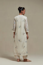 Off white cotton Chanderi straight kurta set with randomly placed blue & beige hand block printed appliquéd flowers, highlighted with sequins and multi coloured beads.