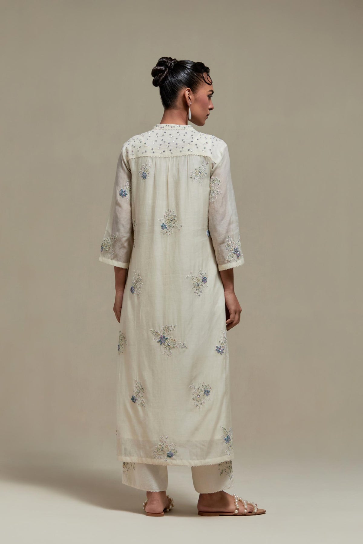 Off white cotton Chanderi straight kurta set with randomly placed blue & beige hand block printed appliquéd flowers, highlighted with sequins and multi coloured beads.