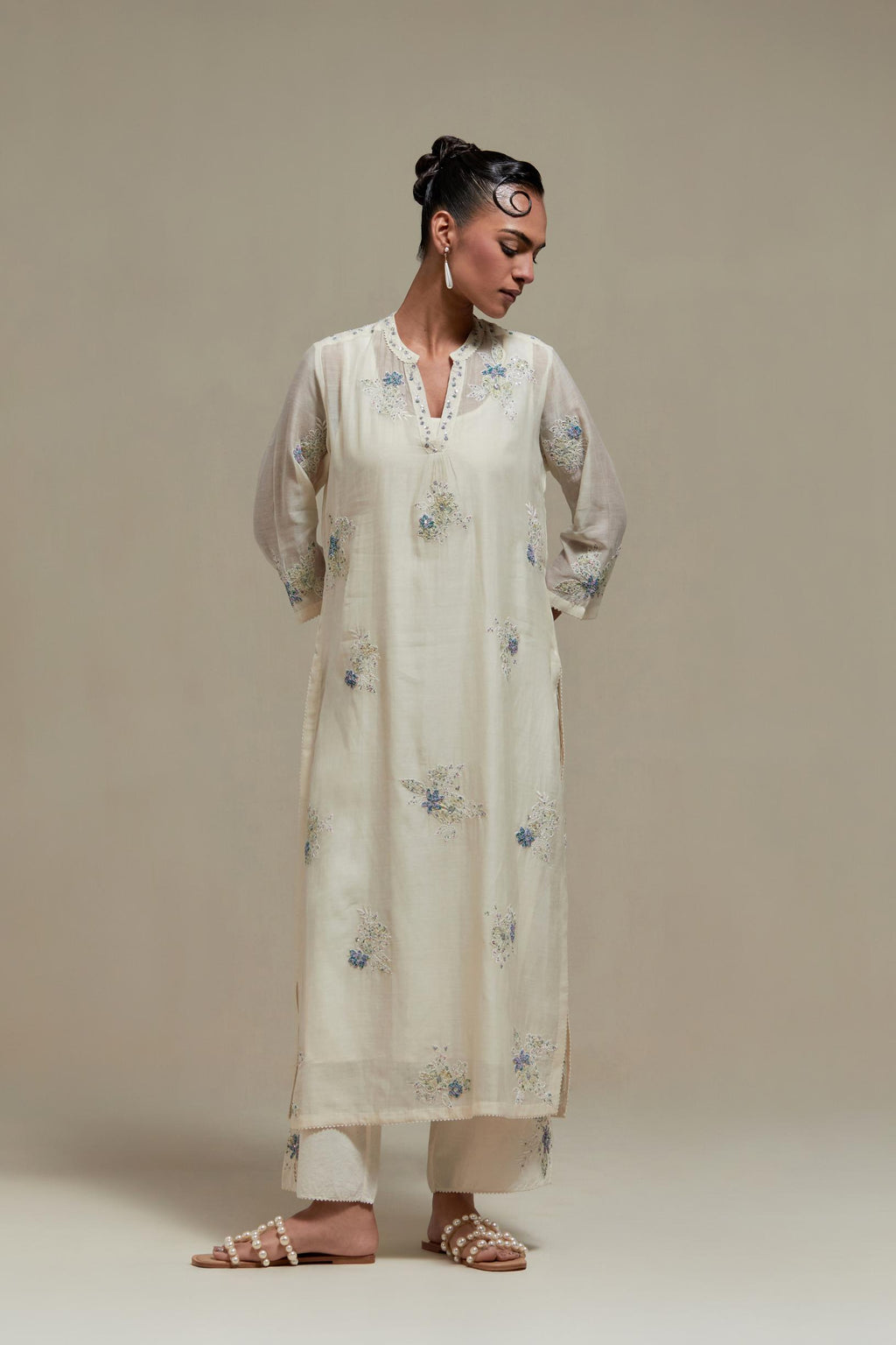 Off white cotton Chanderi straight kurta set with randomly placed blue & beige hand block printed appliquéd flowers, highlighted with sequins and multi coloured beads.
