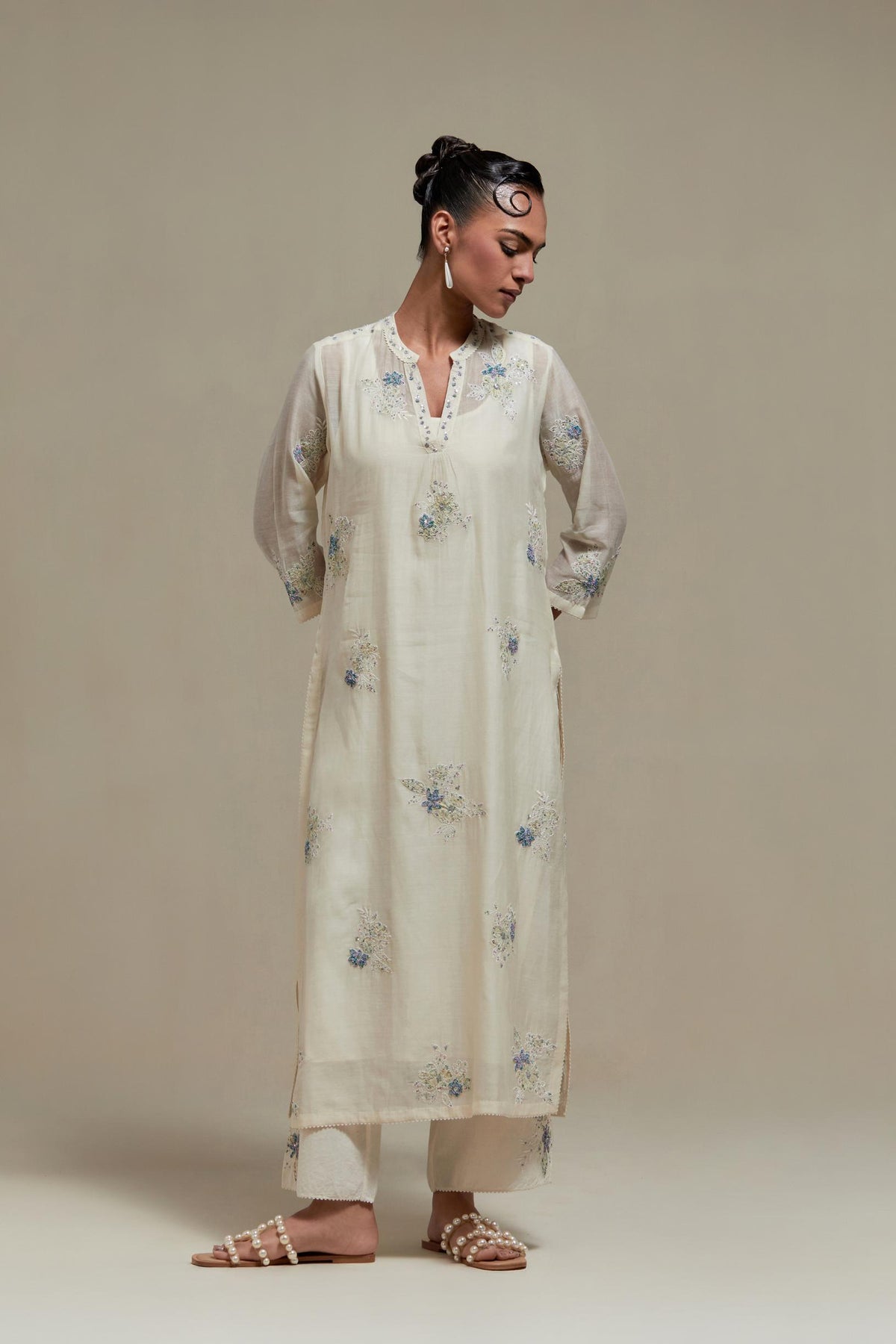 Off white cotton Chanderi straight kurta set with randomly placed blue & beige hand block printed appliquéd flowers, highlighted with sequins and multi coloured beads.