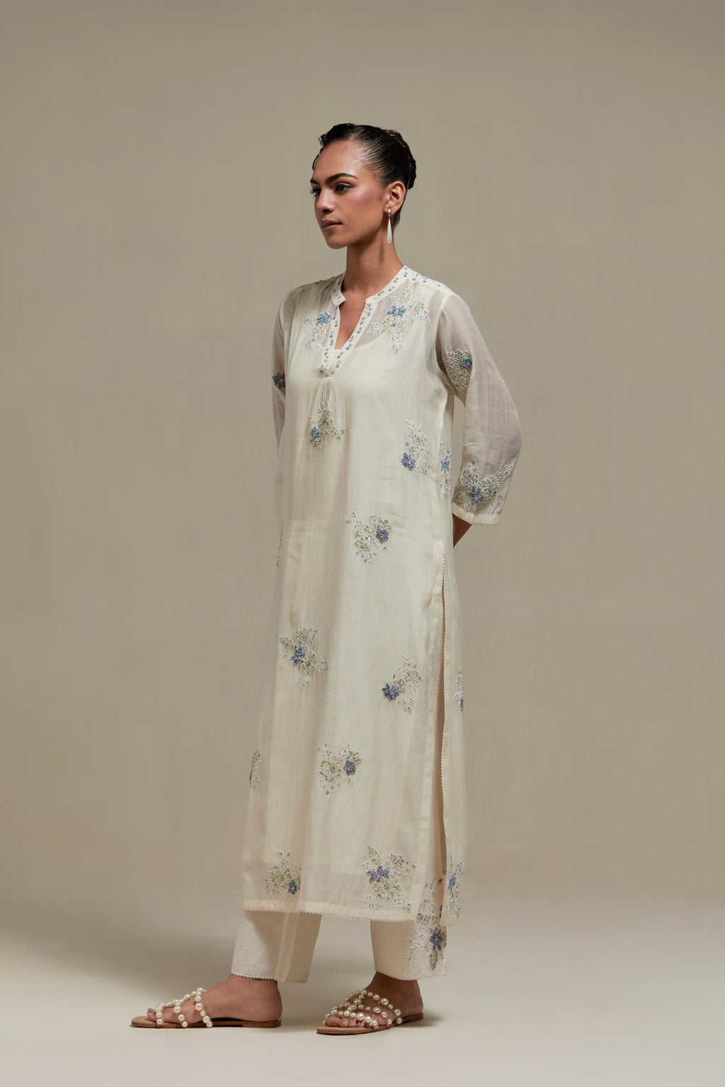 Off white cotton Chanderi straight kurta set with randomly placed blue & beige hand block printed appliquéd flowers, highlighted with sequins and multi coloured beads.