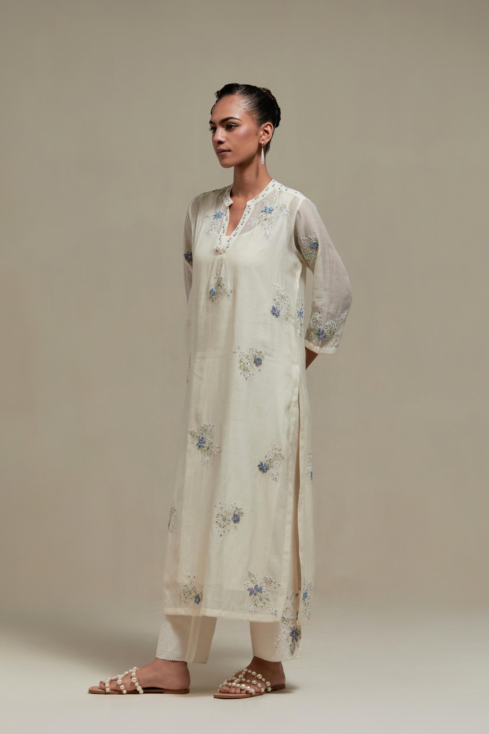 Off white cotton Chanderi straight kurta set with randomly placed blue & beige hand block printed appliquéd flowers, highlighted with sequins and multi coloured beads.
