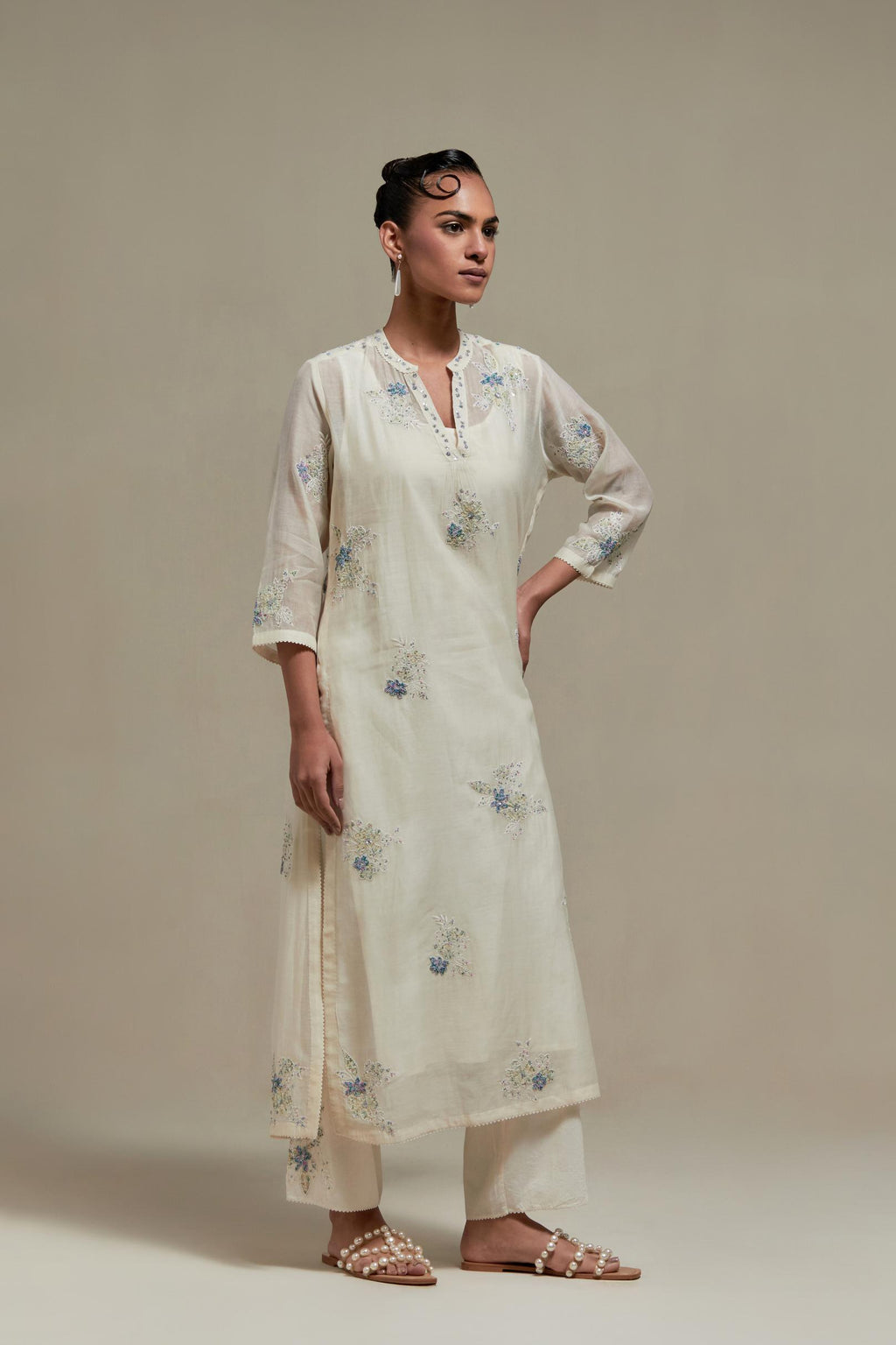 Off white cotton Chanderi straight kurta set with randomly placed blue & beige hand block printed appliquéd flowers, highlighted with sequins and multi coloured beads.