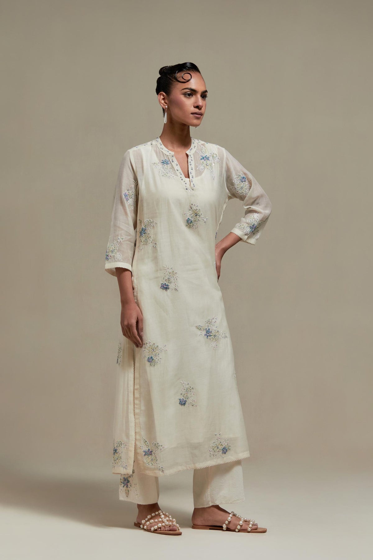 Off white cotton Chanderi straight kurta set with randomly placed blue & beige hand block printed appliquéd flowers, highlighted with sequins and multi coloured beads.