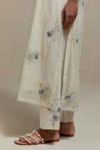 Off white cotton Chanderi straight kurta set with randomly placed blue & beige hand block printed appliquéd flowers, highlighted with sequins and multi coloured beads.