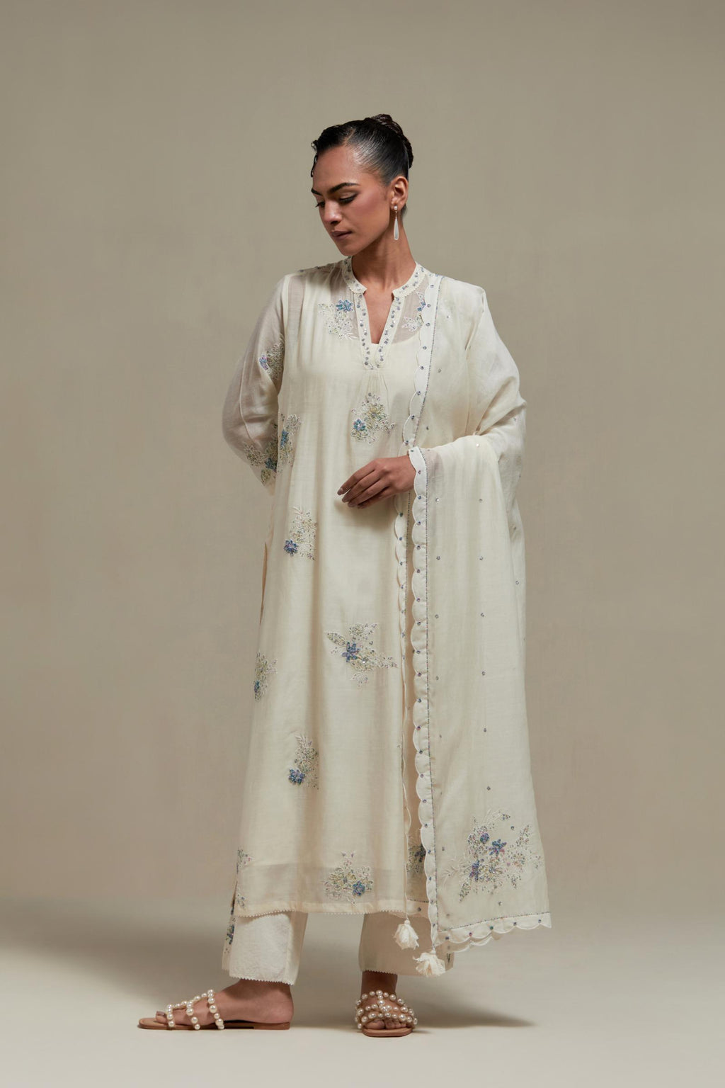 Off white cotton Chanderi dupatta, highlighted with all-over delicate sequins flower and blue & beige hand block printed appliqué motifs at dupatta corners.