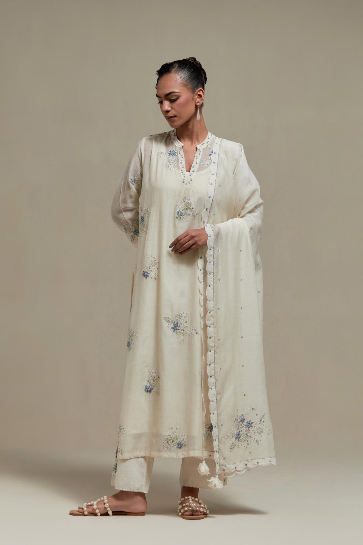 Off white cotton Chanderi straight kurta set with randomly placed blue & beige hand block printed appliquéd flowers, highlighted with sequins and multi coloured beads.