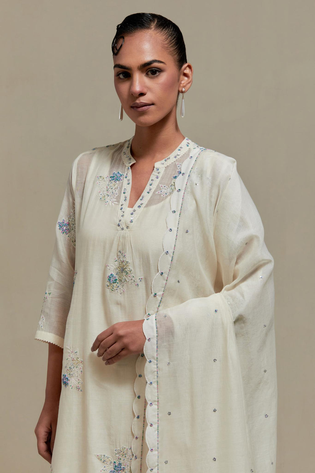 Off white cotton Chanderi dupatta, highlighted with all-over delicate sequins flower and blue & beige hand block printed appliqué motifs at dupatta corners.