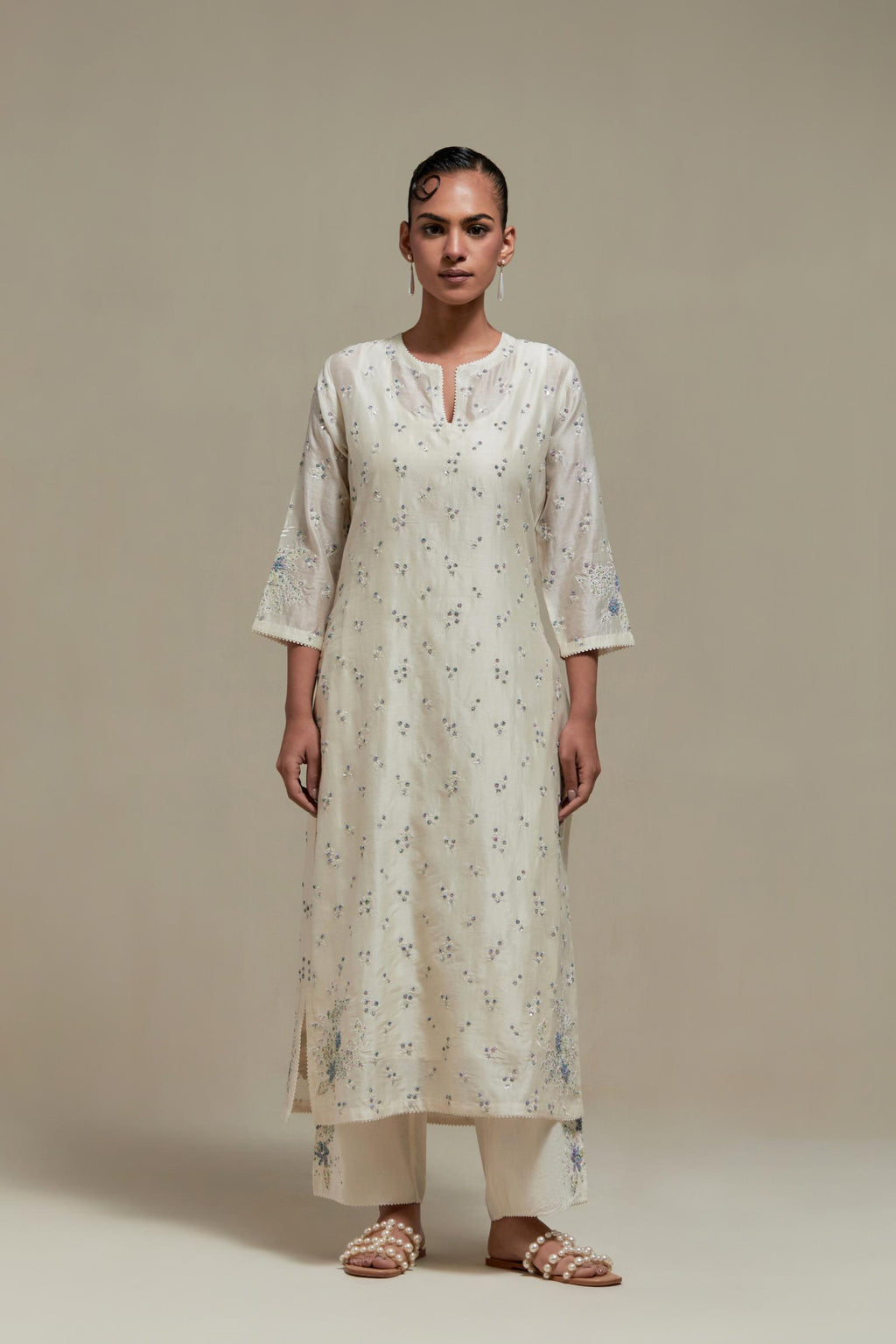 Off white silk Chanderi straight kurta set with all-over delicate embroidered flowers, highlighted with sequins and multi coloured beads.
