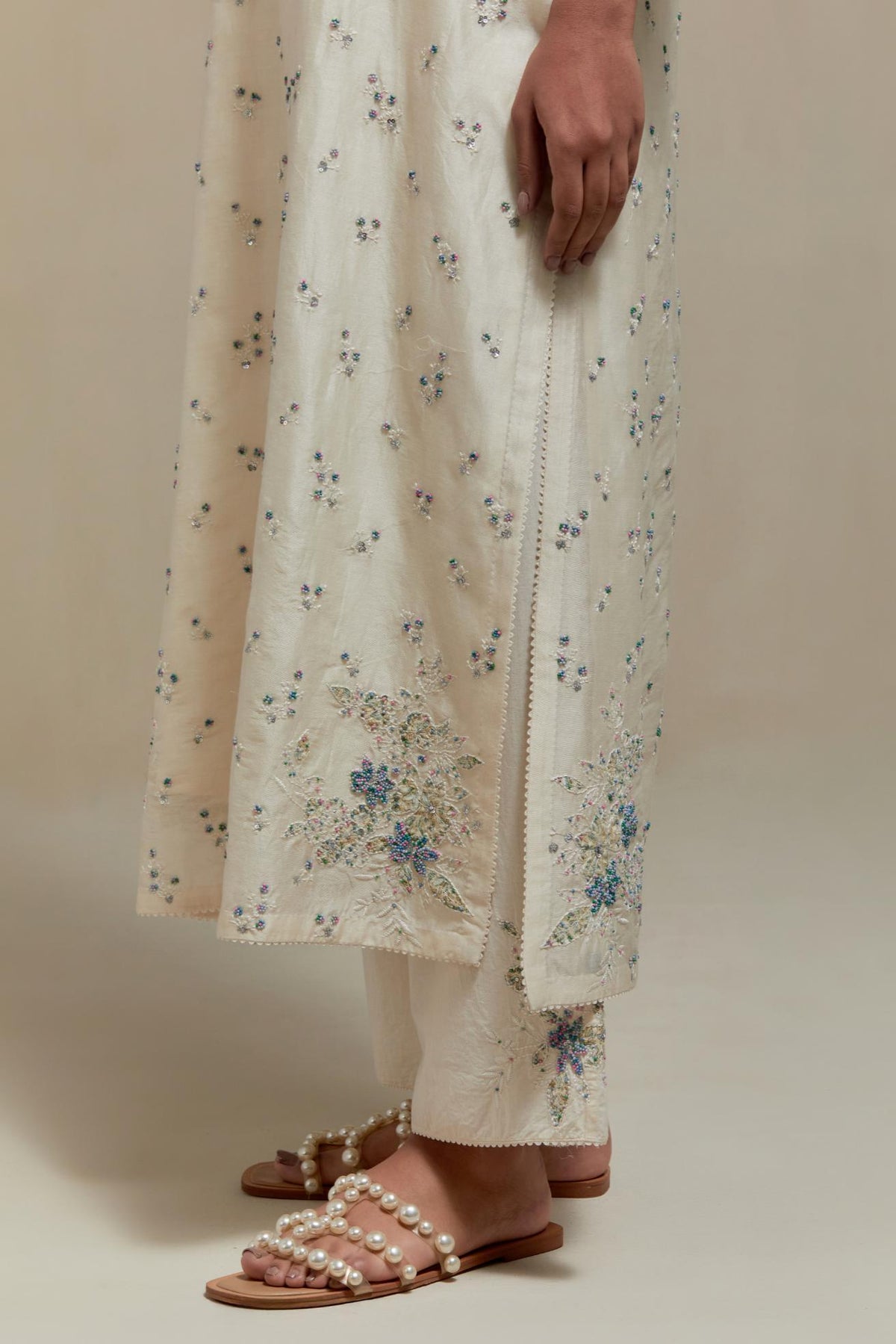 Off white silk Chanderi straight kurta set with all-over delicate embroidered flowers, highlighted with sequins and multi coloured beads.