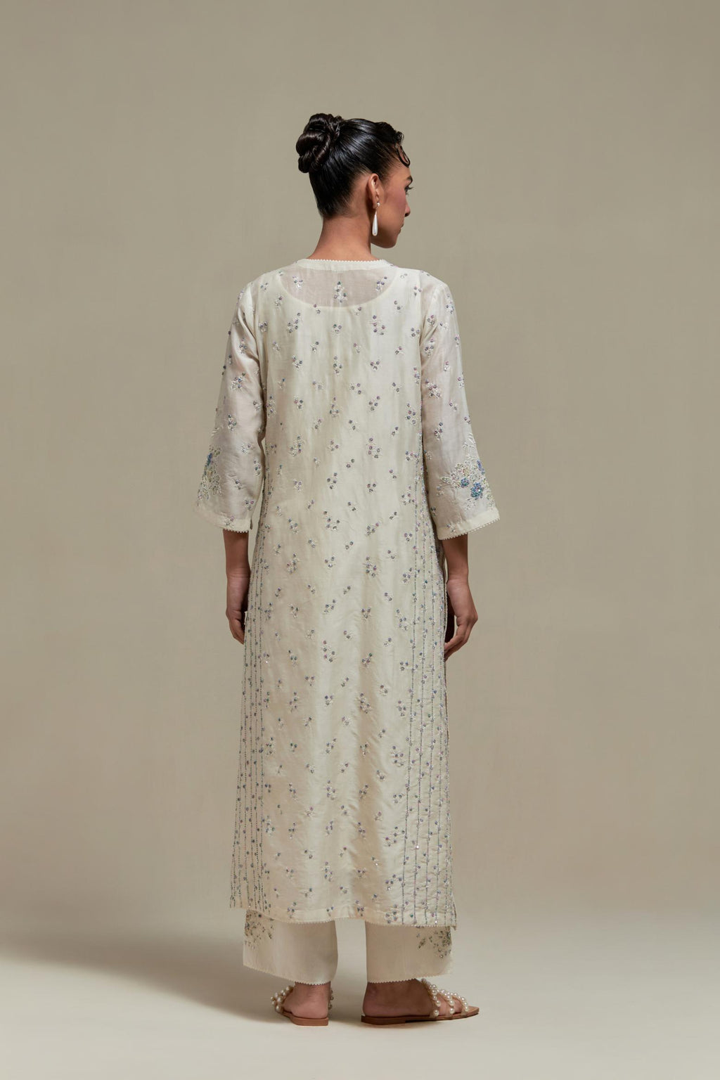 Off white silk Chanderi straight kurta set with all-over delicate embroidered flowers, highlighted with sequins and multi coloured beads.