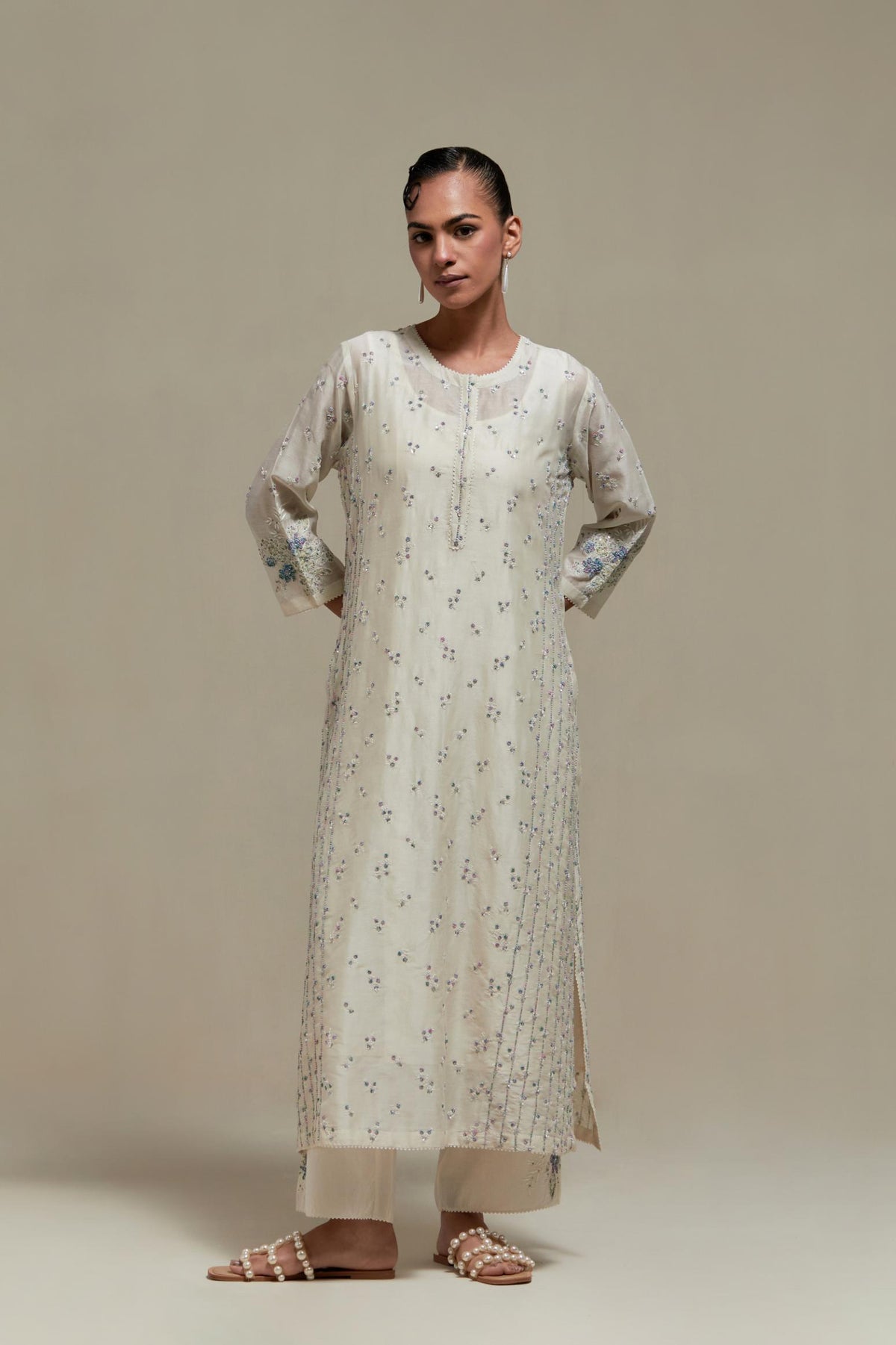 Off white silk Chanderi straight kurta set with all-over delicate embroidered flowers, highlighted with sequins and multi coloured beads.