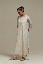 Off white silk Chanderi straight kurta set with all-over delicate embroidered flowers, highlighted with sequins and multi coloured beads.