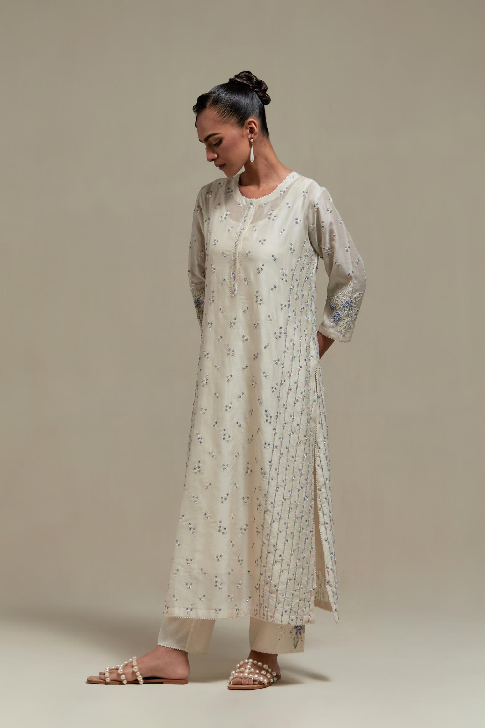 Off white silk Chanderi straight kurta set with all-over delicate embroidered flowers, highlighted with sequins and multi coloured beads.