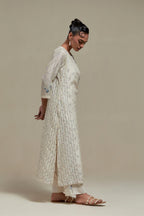 Off white silk Chanderi straight kurta set with all-over delicate embroidered flowers, highlighted with sequins and multi coloured beads.