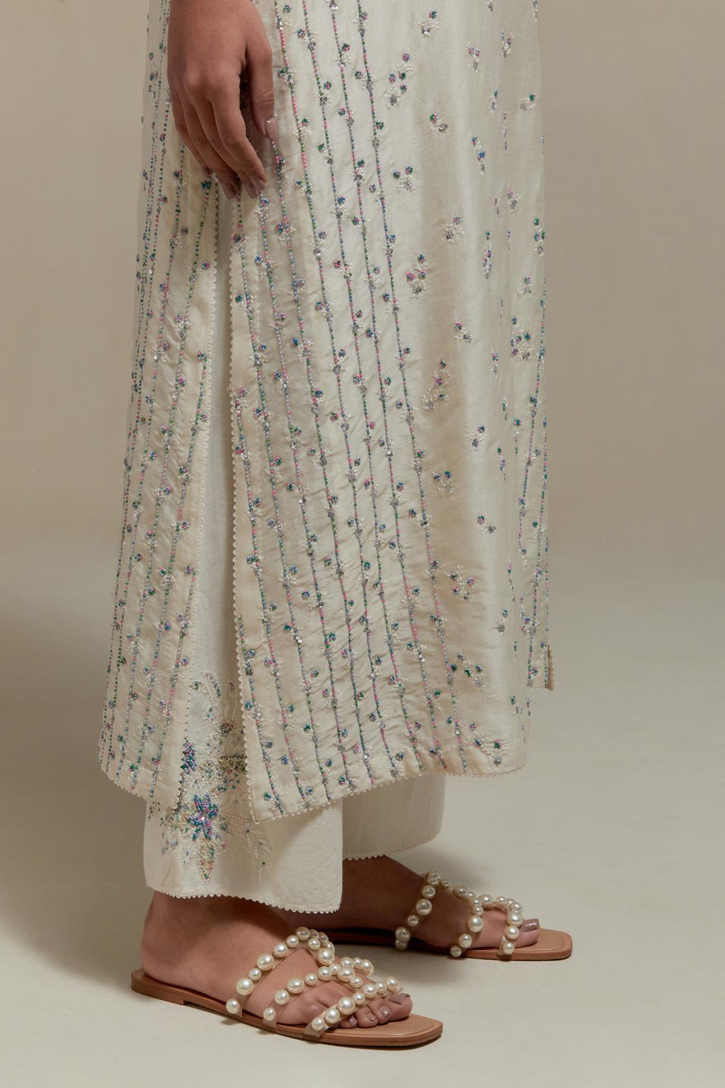 Off white silk Chanderi straight kurta set with all-over delicate embroidered flowers, highlighted with sequins and multi coloured beads.