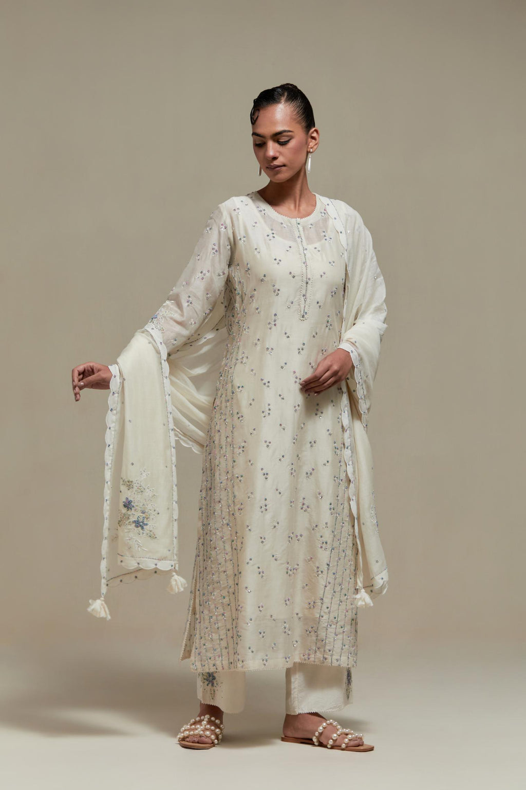 Off white silk Chanderi straight kurta set with all-over delicate embroidered flowers, highlighted with sequins and multi coloured beads.