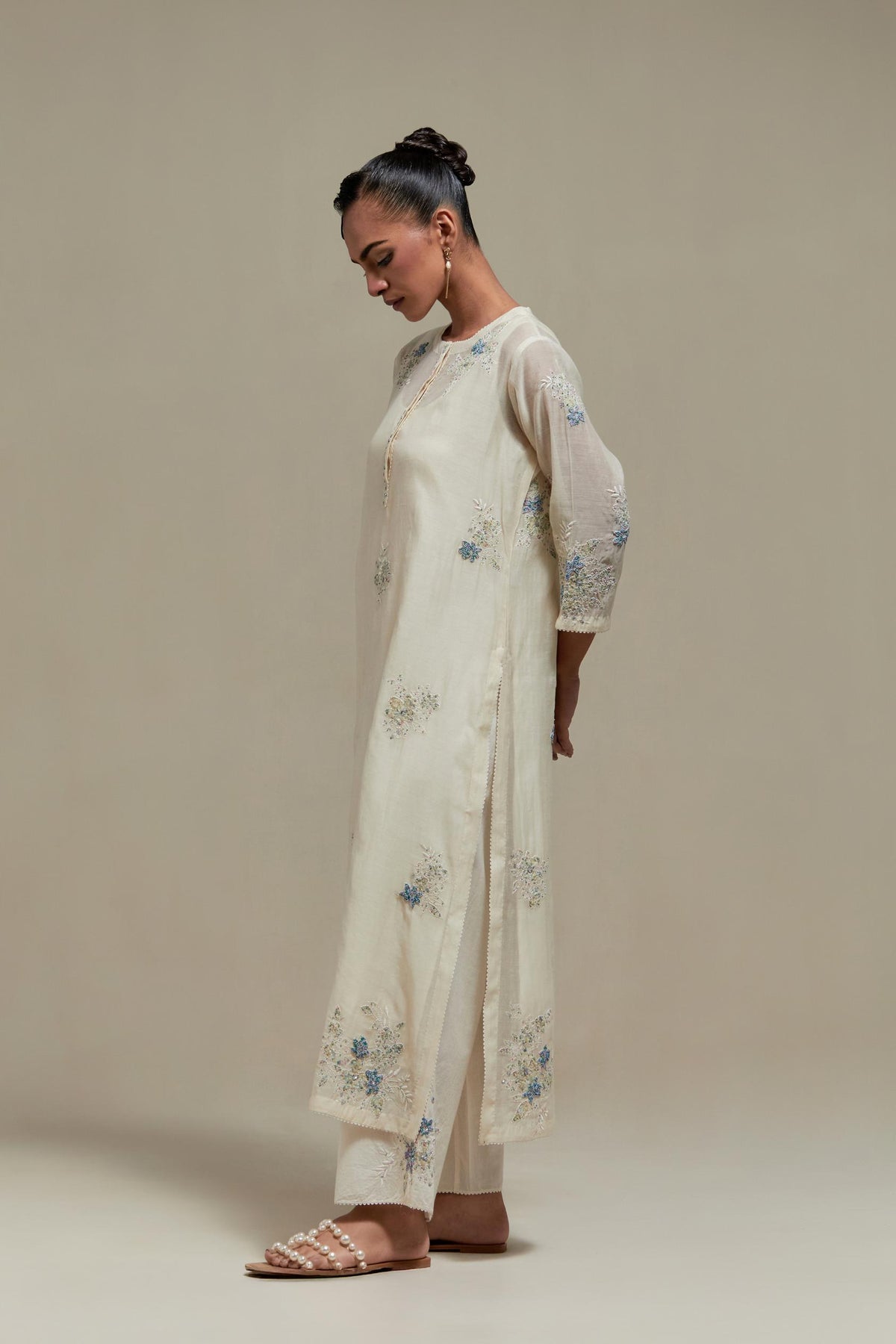 Off white straight kurta set with all-over blue & beige hand block printed appliqué motifs, highlighted with sequins and multi coloured beads.