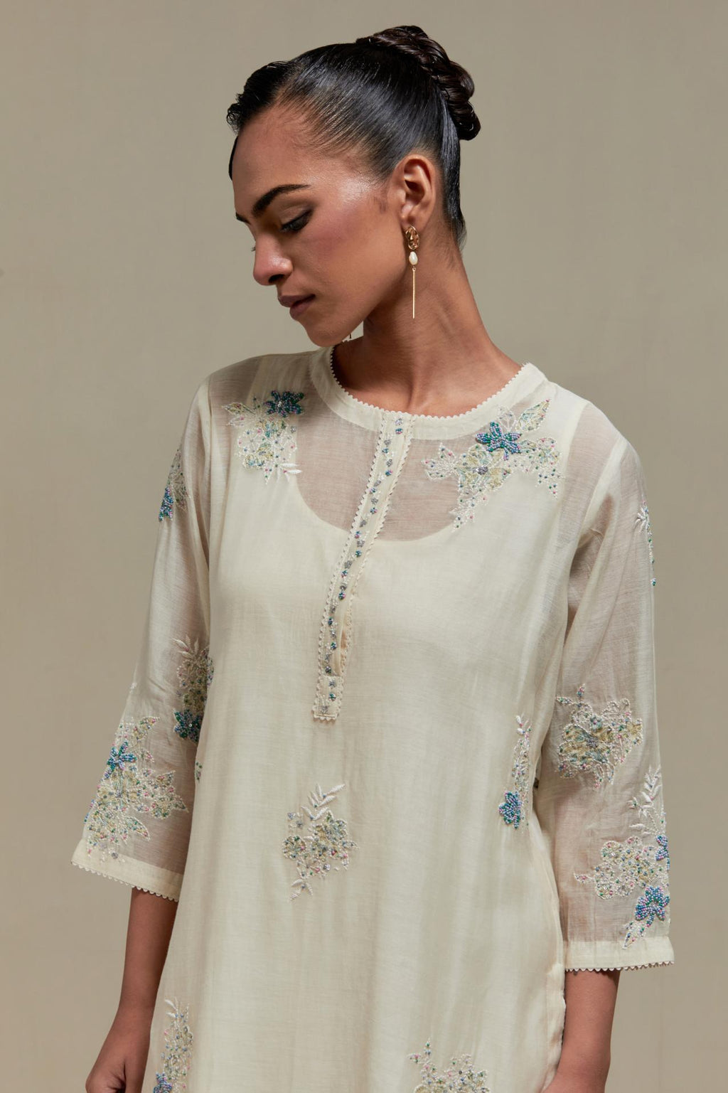 Off white straight kurta set with all-over blue & beige hand block printed appliqué motifs, highlighted with sequins and multi coloured beads.