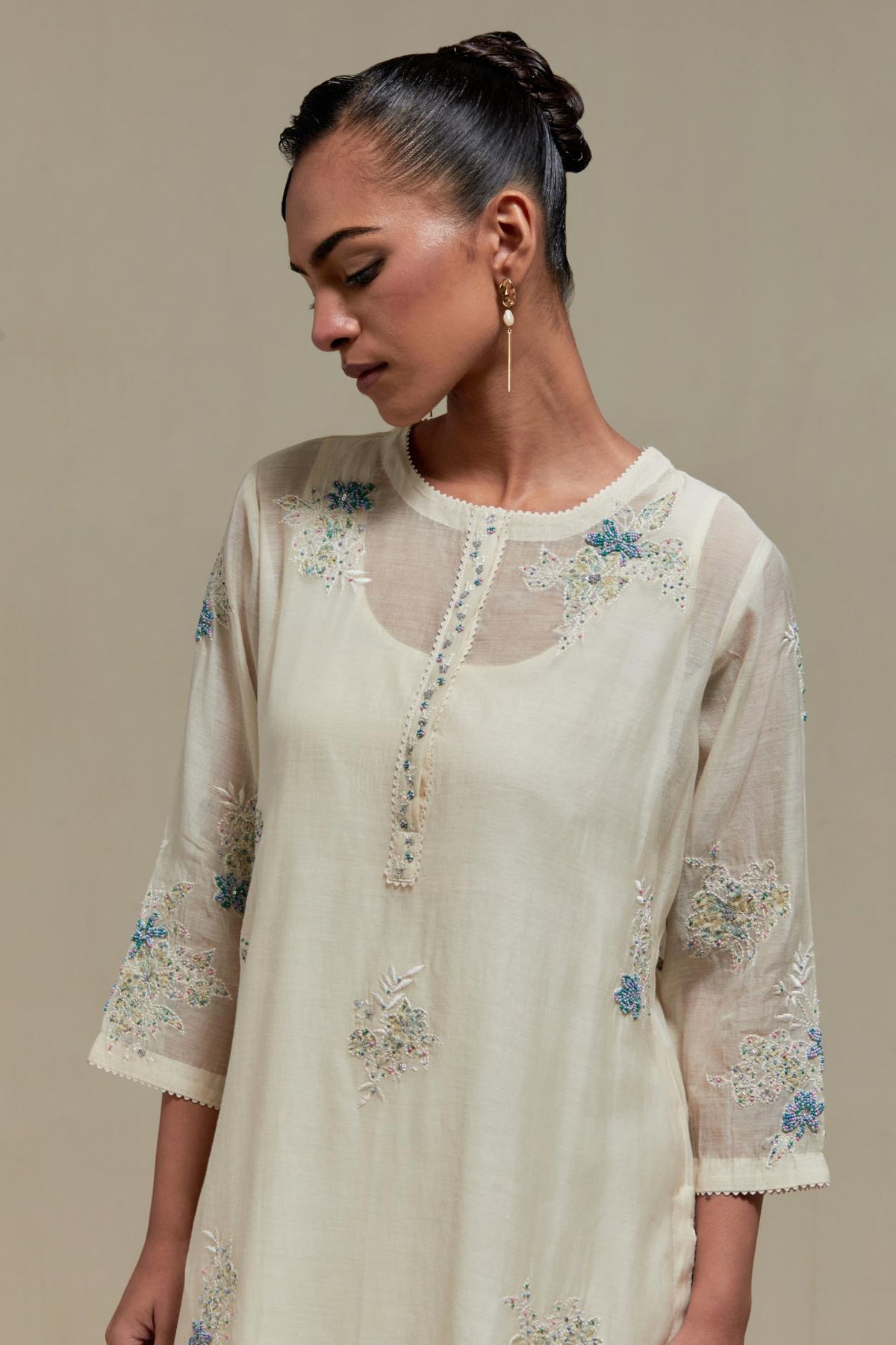 Off white straight kurta set with all-over blue & beige hand block printed appliqué motifs, highlighted with sequins and multi coloured beads.