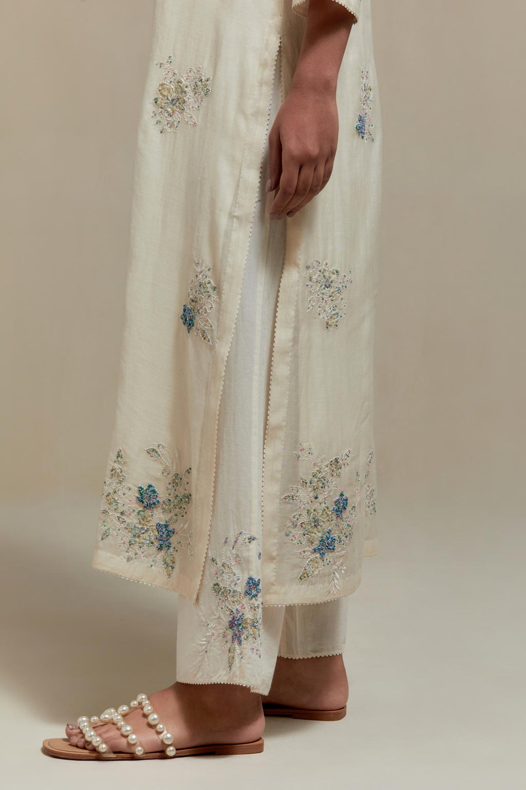 Off white straight kurta set with all-over blue & beige hand block printed appliqué motifs, highlighted with sequins and multi coloured beads.
