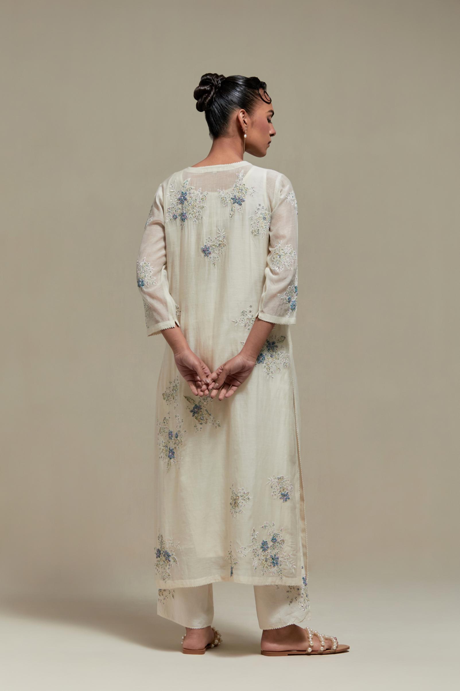 Off white cotton Chanderi straight kurta set with randomly placed blue & beige hand block printed appliquéd flowers, highlighted with sequins and multi colored beads.
