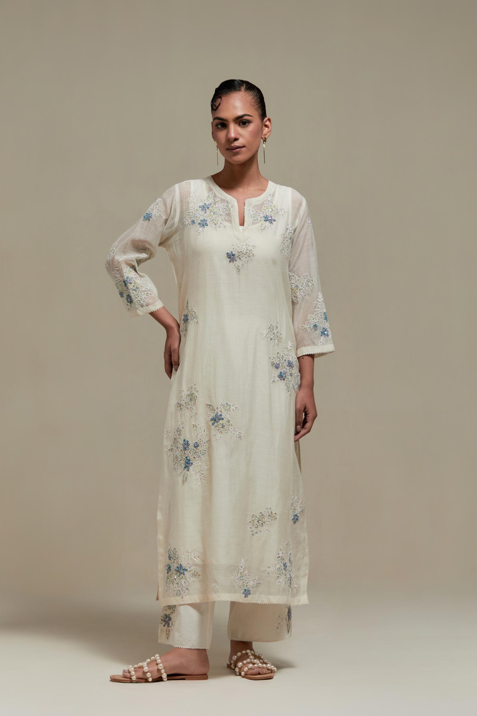 Off white cotton Chanderi straight kurta set with randomly placed blue & beige hand block printed appliquéd flowers, highlighted with sequins and multi colored beads.