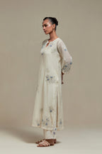 Off white cotton Chanderi straight kurta set with randomly placed blue & beige hand block printed appliquéd flowers, highlighted with sequins and multi colored beads.