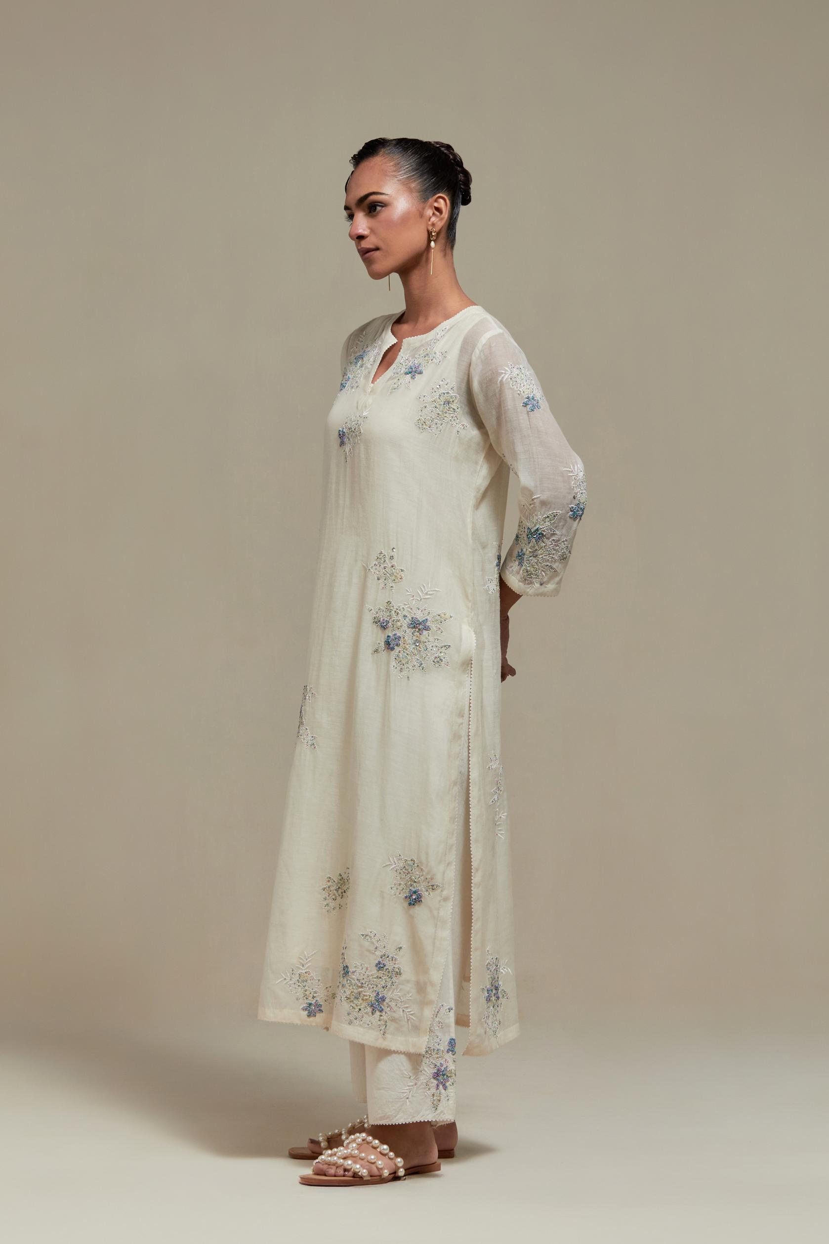 Off white cotton Chanderi straight kurta set with randomly placed blue & beige hand block printed appliquéd flowers, highlighted with sequins and multi colored beads.