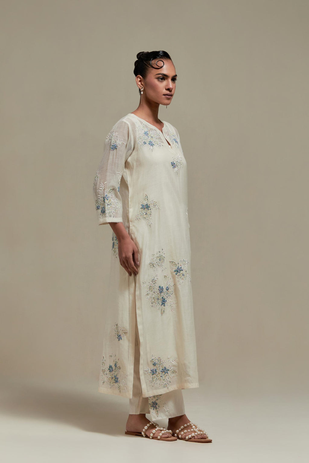 Off white cotton Chanderi straight kurta set with randomly placed blue & beige hand block printed appliquéd flowers, highlighted with sequins and multi colored beads.