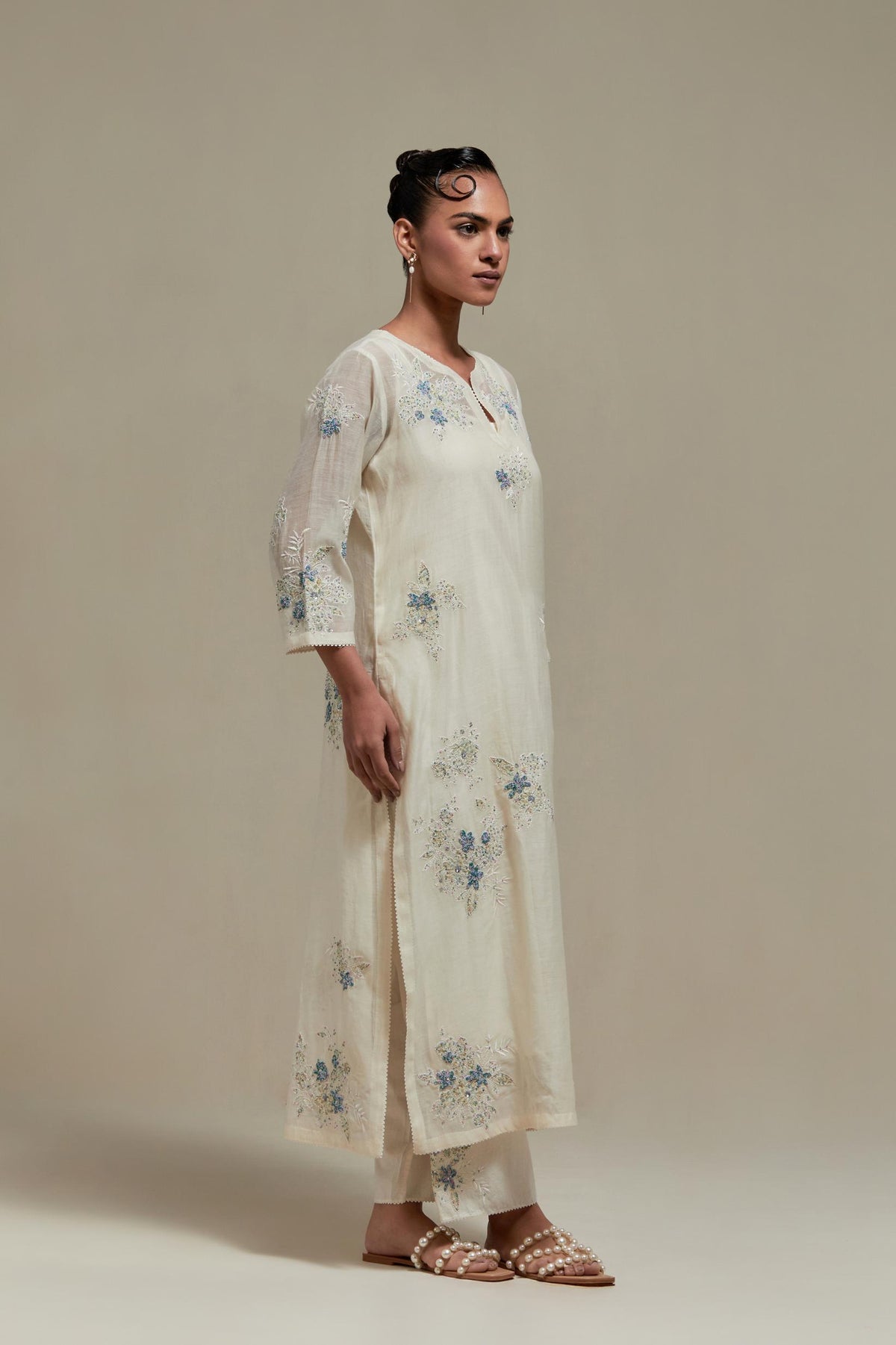 Off white cotton Chanderi straight kurta set with randomly placed blue & beige hand block printed appliquéd flowers, highlighted with sequins and multi colored beads.