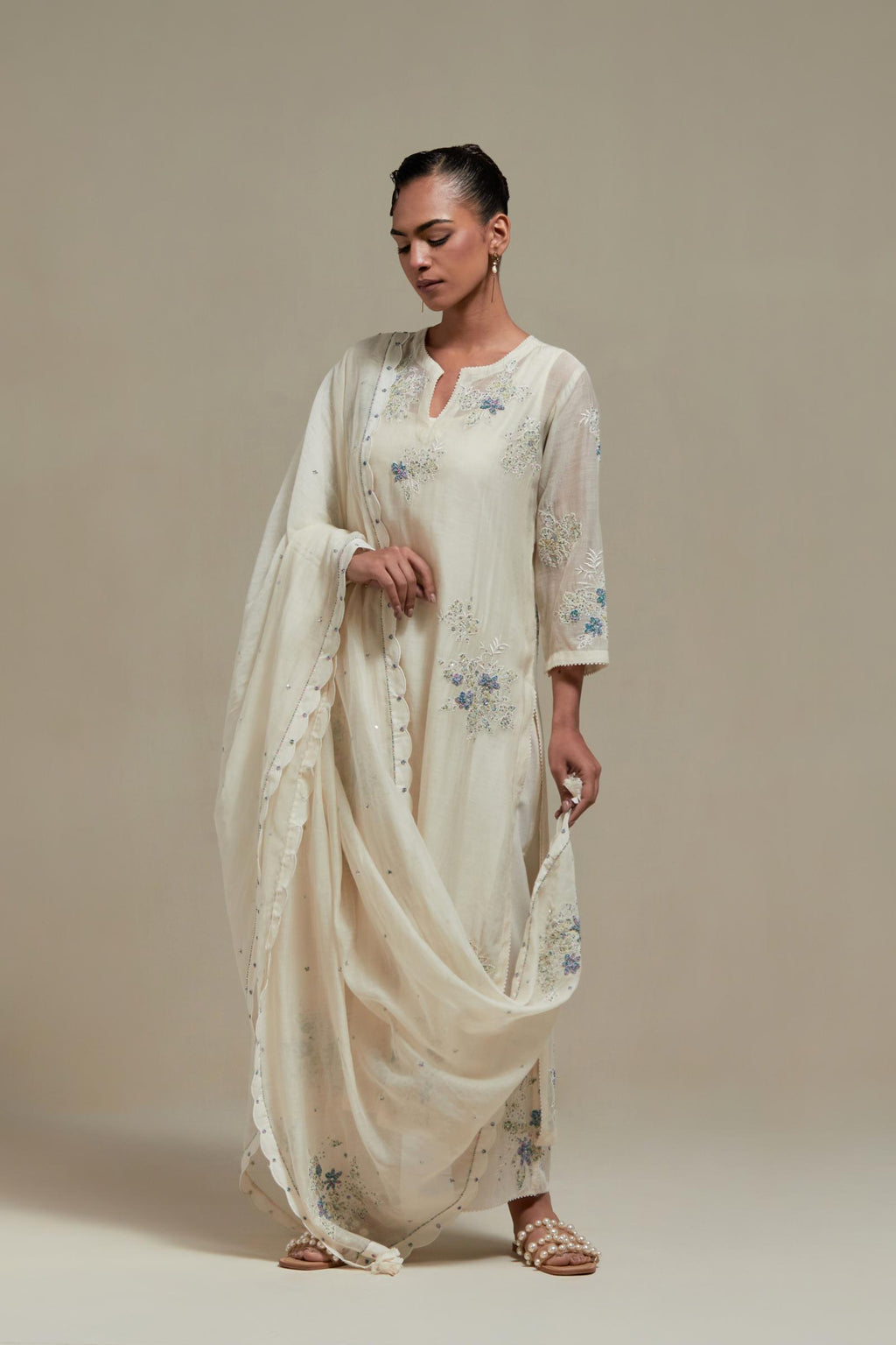 Off white cotton Chanderi straight kurta set with randomly placed blue & beige hand block printed appliquéd flowers, highlighted with sequins and multi colored beads.