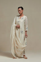 Off white cotton Chanderi straight kurta set with randomly placed blue & beige hand block printed appliquéd flowers, highlighted with sequins and multi colored beads.