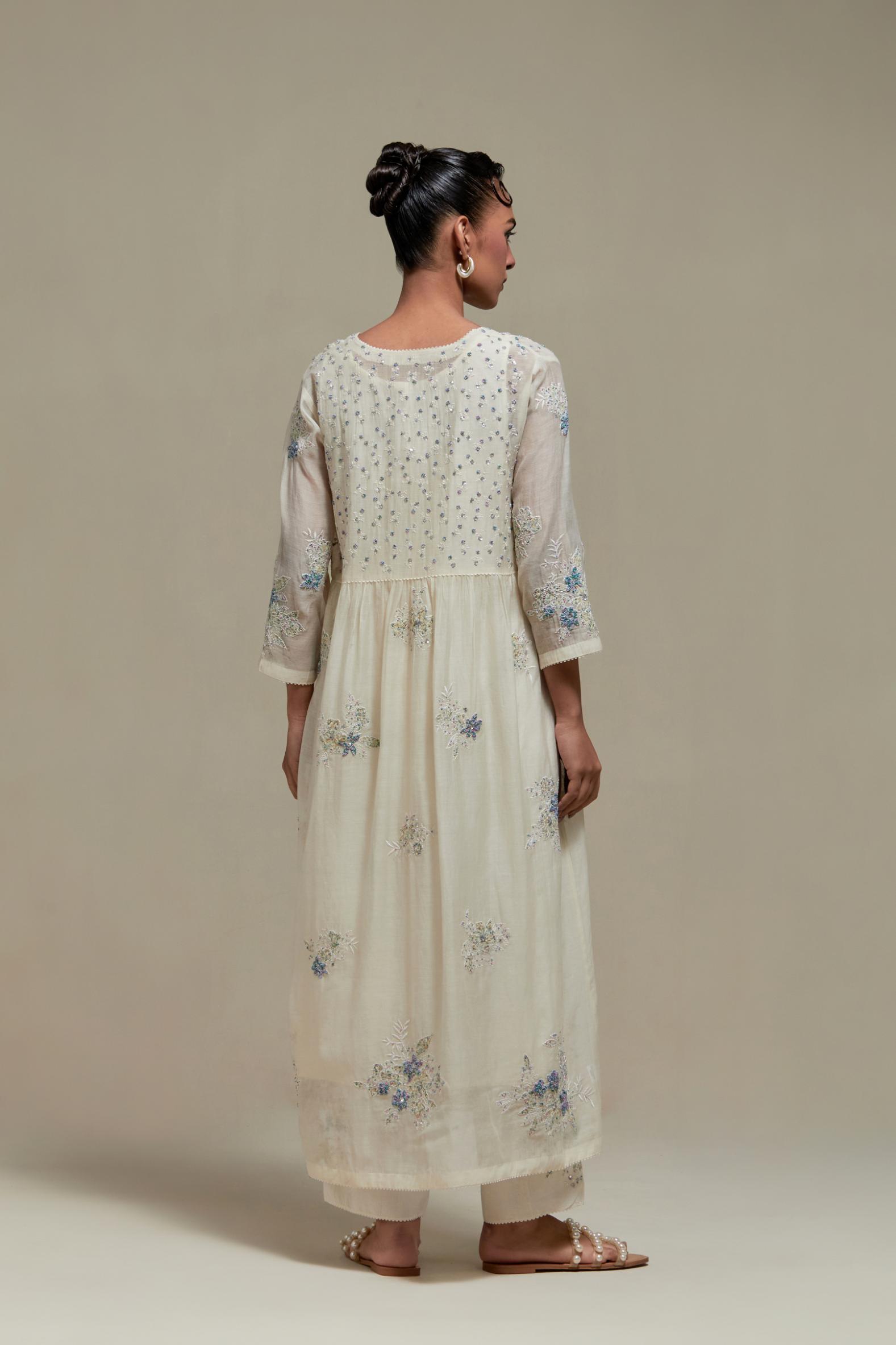 Off white cotton Chanderi kurta dress set with delicate embroidered flowers and blue & beige hand block printed appliqué motifs, highlighted with sequins and multi coloured beads.