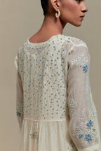 Off white cotton Chanderi kurta dress set with delicate embroidered flowers and blue & beige hand block printed appliqué motifs, highlighted with sequins and multi coloured beads.