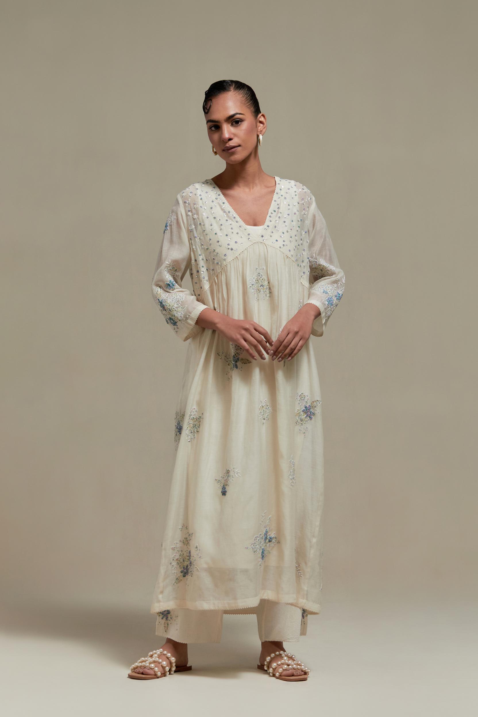 Off white cotton Chanderi kurta dress set with delicate embroidered flowers and blue & beige hand block printed appliqué motifs, highlighted with sequins and multi coloured beads.