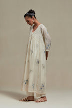 Off white cotton Chanderi kurta dress set with delicate embroidered flowers and blue & beige hand block printed appliqué motifs, highlighted with sequins and multi coloured beads.