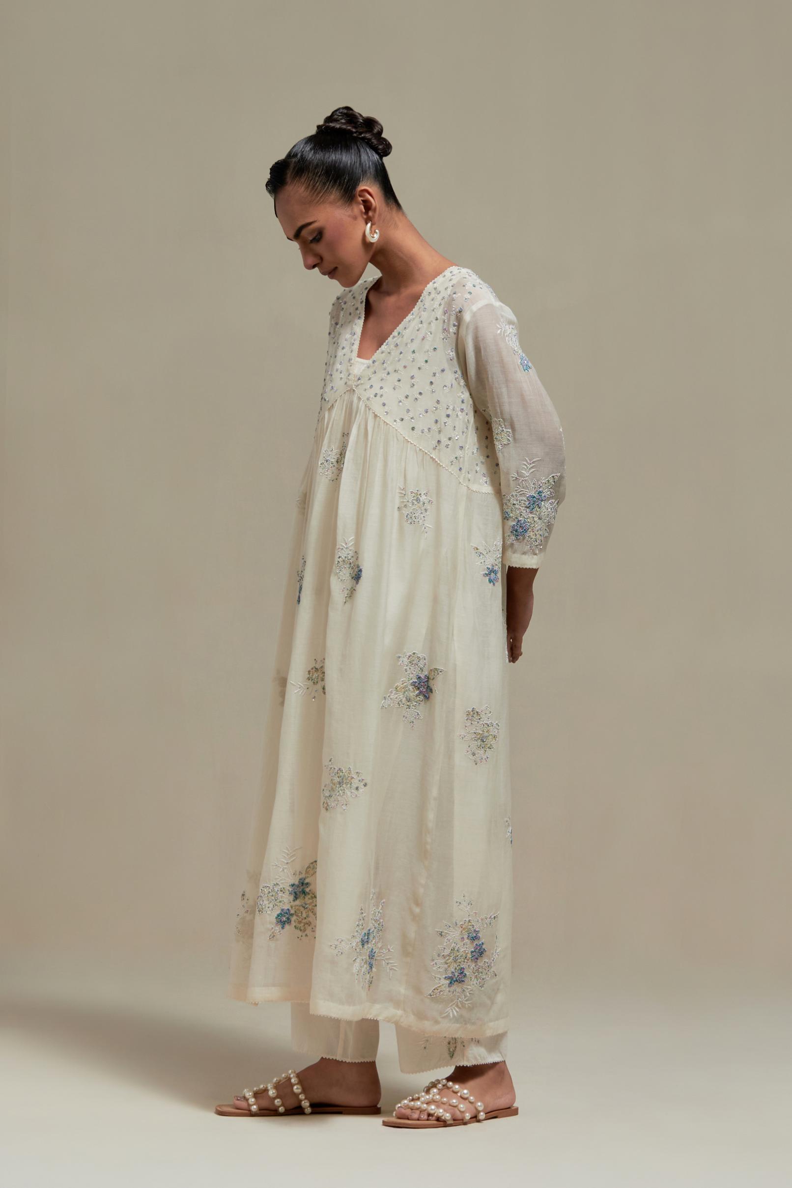 Off white cotton Chanderi kurta dress set with delicate embroidered flowers and blue & beige hand block printed appliqué motifs, highlighted with sequins and multi coloured beads.