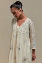 Off white cotton Chanderi kurta dress set with delicate embroidered flowers and blue & beige hand block printed appliqué motifs, highlighted with sequins and multi coloured beads.