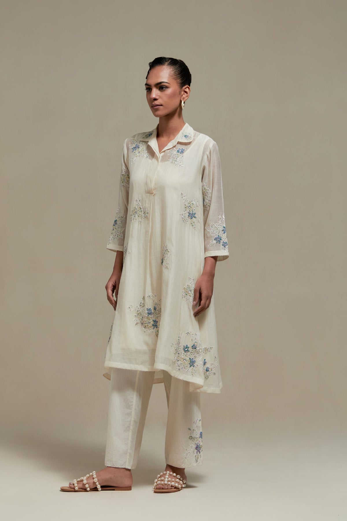 Off white cotton Chanderi short shirt-kurta set with all-over blue & beige hand block printed appliqué flowers, highlighted with sequins and multi-coloured beads.