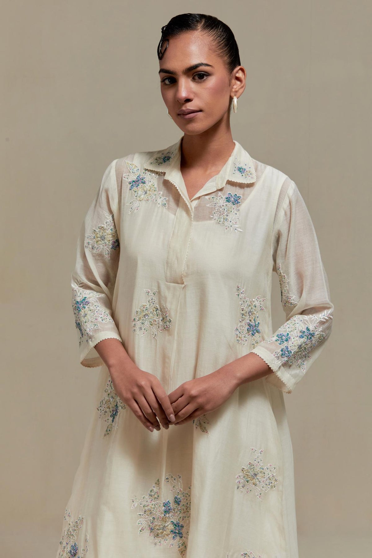 Off white cotton Chanderi short shirt-kurta set with all-over blue & beige hand block printed appliqué flowers, highlighted with sequins and multi-coloured beads.