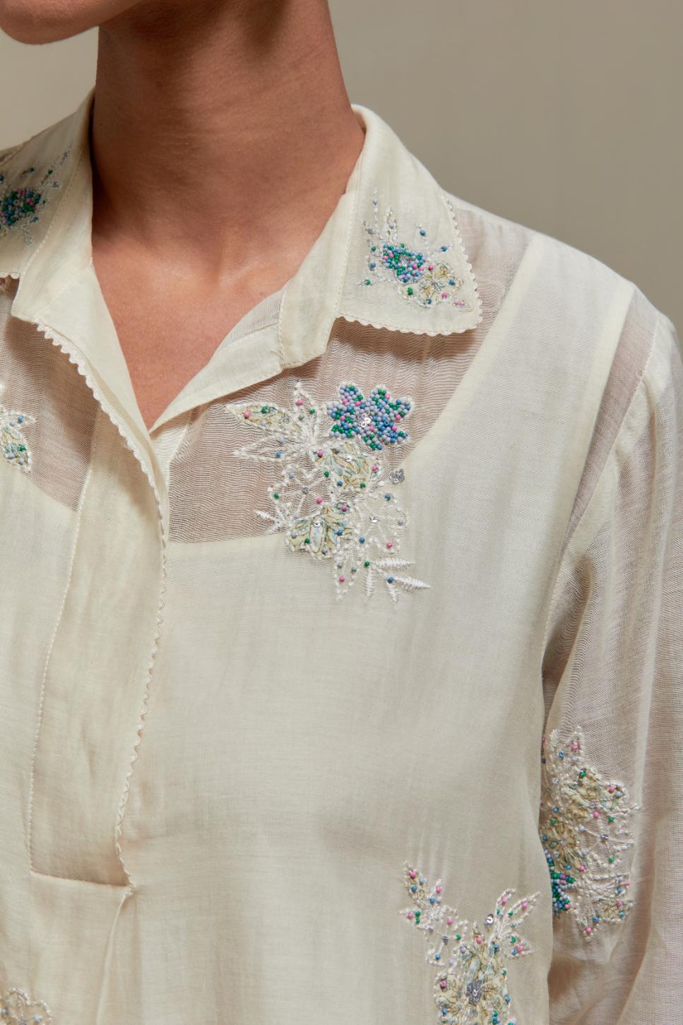 Off white cotton Chanderi short shirt-kurta set with all-over blue & beige hand block printed appliqué flowers, highlighted with sequins and multi-coloured beads.